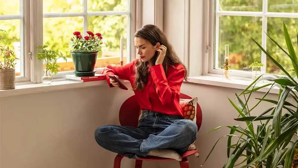 Kvinna läser ekonomiböcker på mobilen